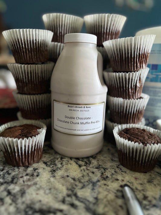 Bottle of chocolate muffin mix with chocolate muffins on a countertop